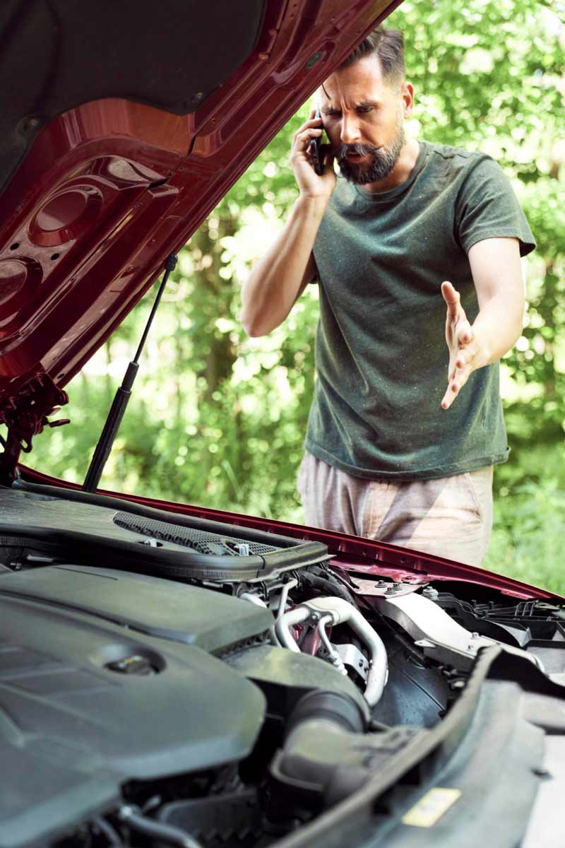 Junger Mann prüft Getriebeschaden bei Schrottauto Ankauf Wittlich